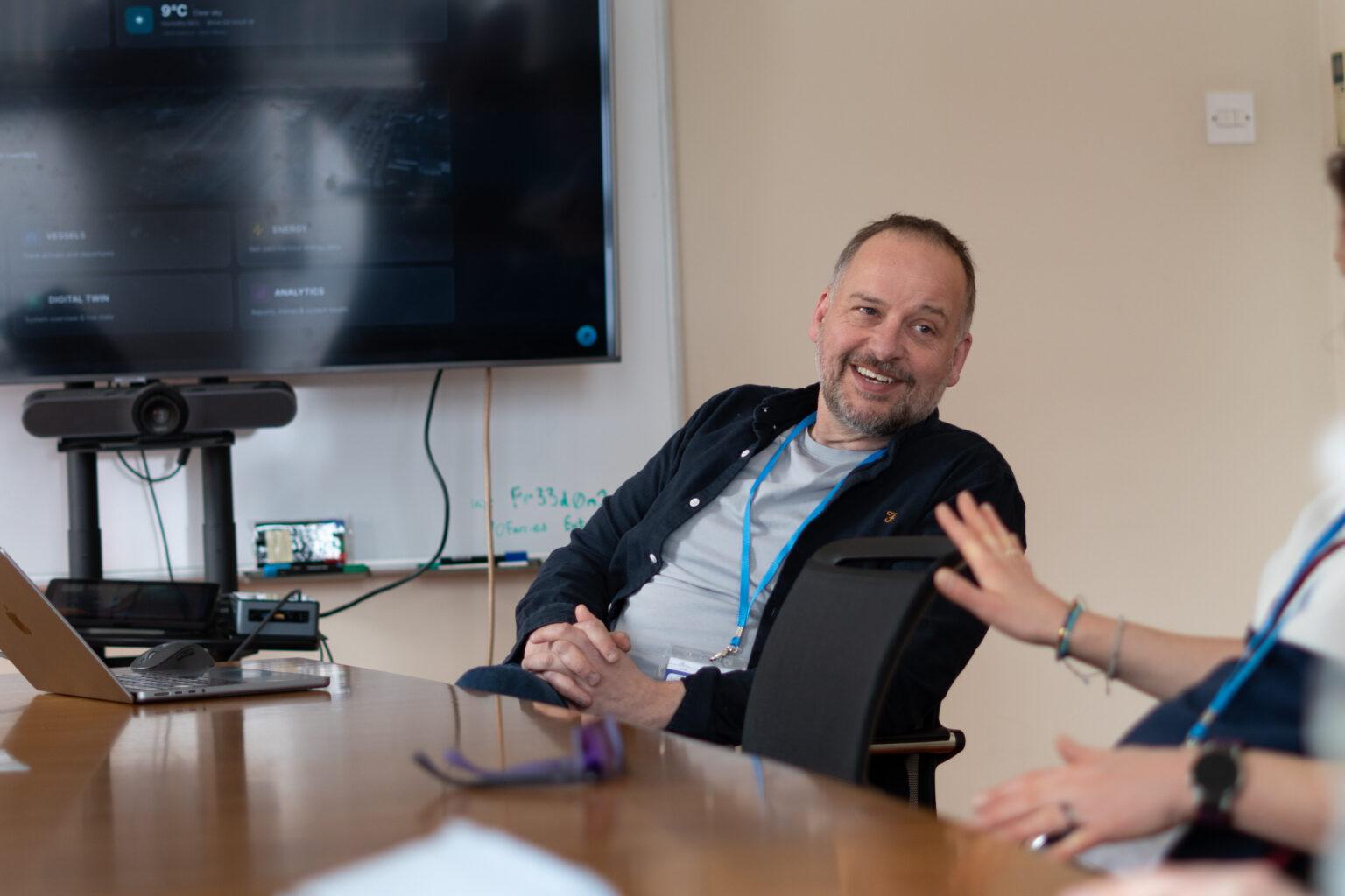 Helix8 CEO John Harrison at the Port of Larne offices, with the live digital twin dashboard on screen